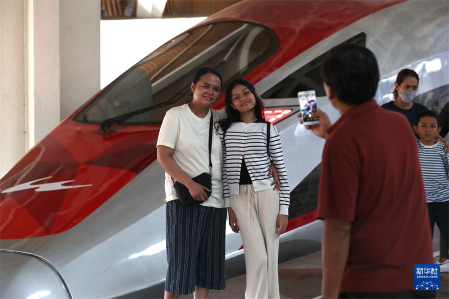 6月19日，在印度尼西亞雅加達(dá)哈利姆站站臺(tái)，兩名乘客與雅萬(wàn)高鐵高速動(dòng)車(chē)組列車(chē)合影。新華社記者 岑云鵬 攝