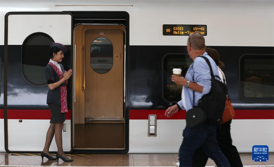 6月19日，一名乘務(wù)人員在印度尼西亞雅加達(dá)哈利姆站站臺歡迎乘客。新華社記者 岑云鵬 攝