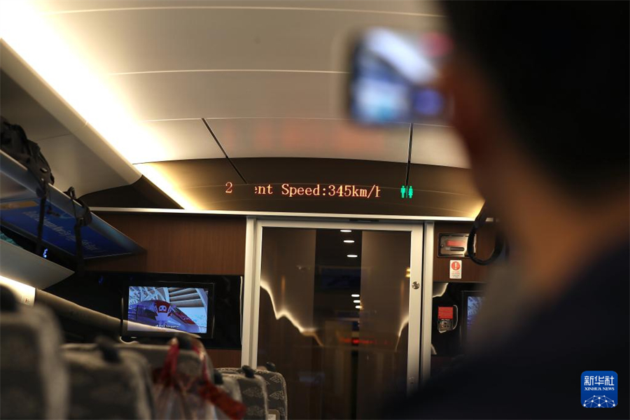 6月19日，一名乘客在行駛中的雅萬高鐵車廂內(nèi)拍攝列車時速。新華社記者 岑云鵬 攝