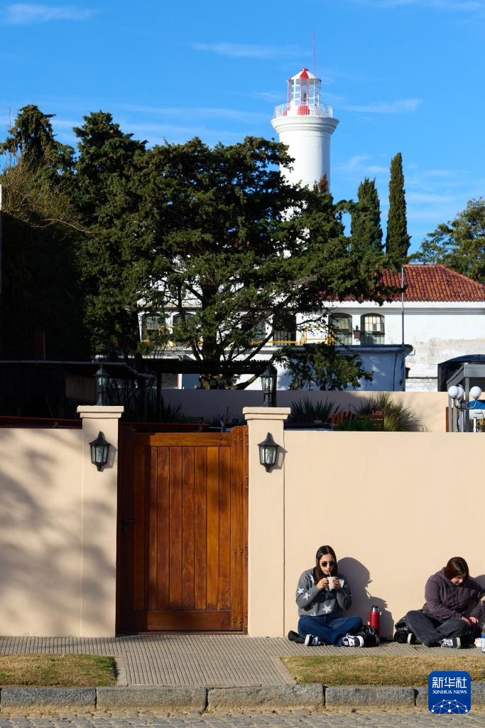 6月25日，兩名女子坐在烏拉圭科洛尼亞的老城區(qū)街頭。新華社記者 孟鼎博 攝