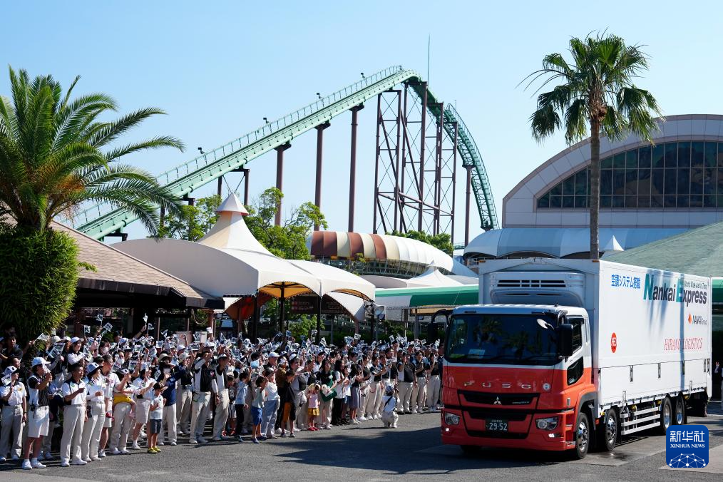 6月28日，工作人員與當(dāng)?shù)孛癖娫谌毡竞透枭娇h冒險(xiǎn)世界游樂園外目送運(yùn)輸大熊貓的卡車離開。新華社記者 賈浩成 攝