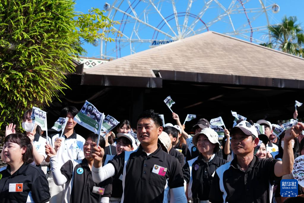 6月28日，工作人員與當(dāng)?shù)孛癖娫谌毡竞透枭娇h冒險(xiǎn)世界游樂園外目送運(yùn)輸大熊貓的卡車離開。新華社記者 賈浩成 攝