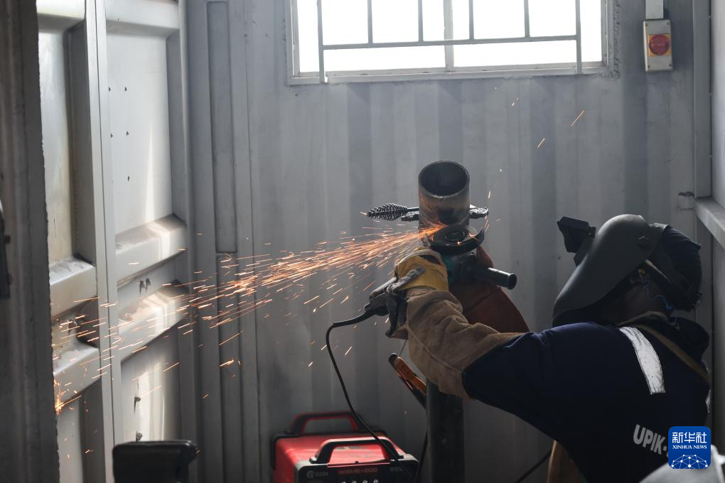 6月16日，在烏干達基貢巴石油學院，學員西爾弗在打磨焊接管件。新華社發(fā)（中石化供圖）