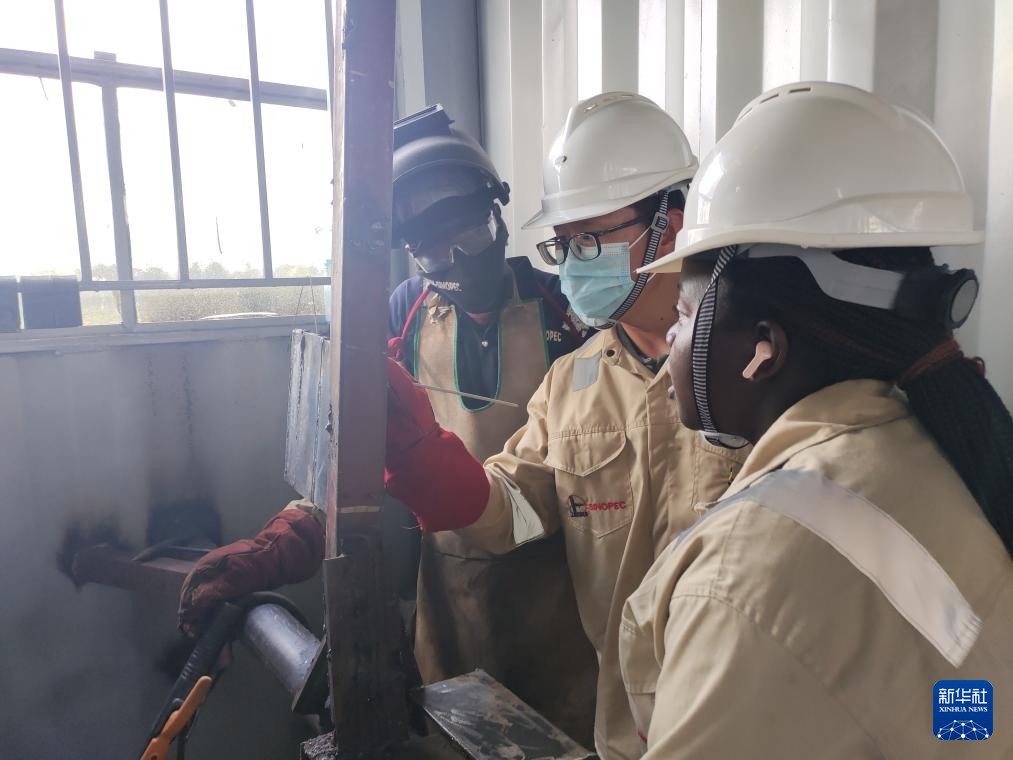 6月11日，在烏干達基貢巴石油學院，中國老師湯海東（中）為學員講解焊接要點。新華社發(fā)（中石化供圖）