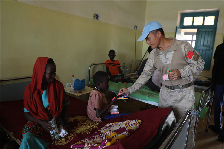 圖為維和官兵為患病兒童贈送小禮品。張曉昆攝
