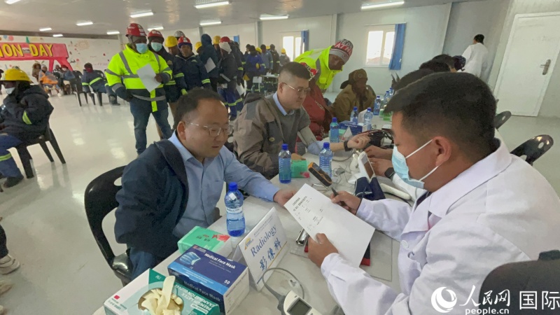 為當(dāng)?shù)鼐用駲z測體溫。人民網(wǎng)記者 鄒松攝