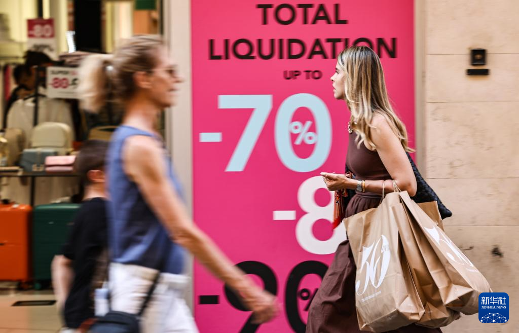 7月5日，一名女子提著購物袋走在意大利羅馬街頭。新華社記者 李京 攝