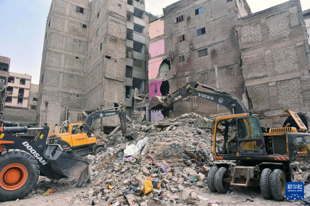 7月5日，在巴基斯坦南部港口城市卡拉奇，救援人員在住宅樓廢墟中開(kāi)展搜救工作。新華社發(fā)