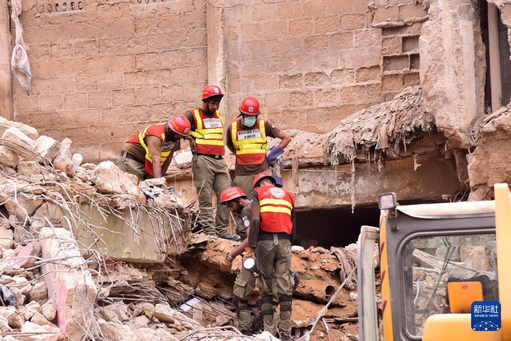 7月5日，在巴基斯坦南部港口城市卡拉奇，救援人員在住宅樓廢墟中開(kāi)展搜救工作。新華社發(fā)