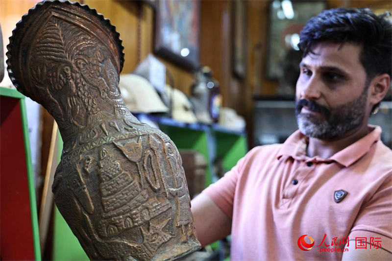 一名參觀者在欣賞一個(gè)舊銅壺。人民網(wǎng)伊納斯·易卜拉欣攝