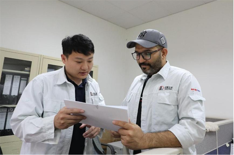 穆德海希爾（右）與中方員工在核對材料清單。中石化南京工程公司供圖