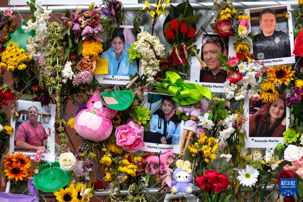 7月12日，在美國(guó)得克薩斯州克爾維爾，人們將悼念的鮮花插在洪災(zāi)遇難者的照片旁。新華社發(fā)（尼克·瓦格納攝）