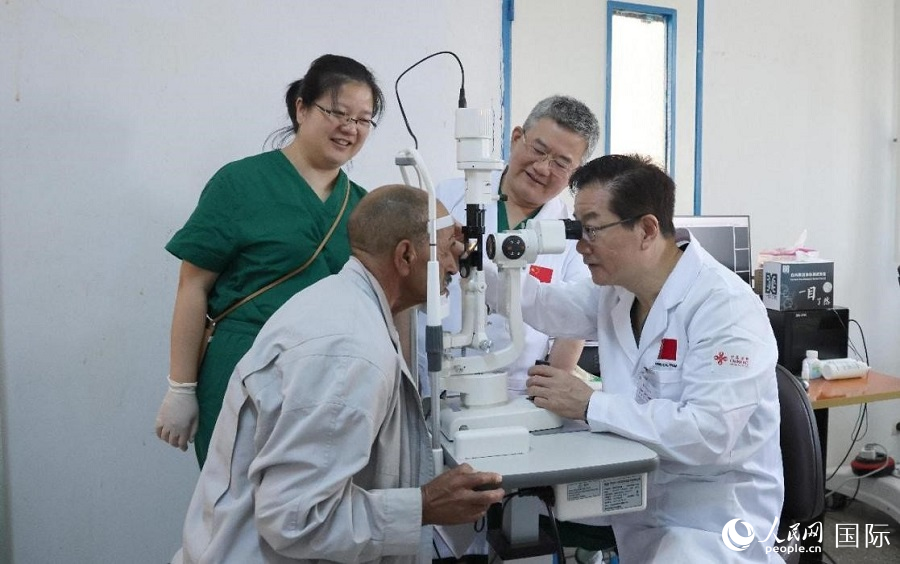 范先群院士（右一）在為摩洛哥白內(nèi)障患者進行眼科檢查。人民網(wǎng)記者 管克江攝