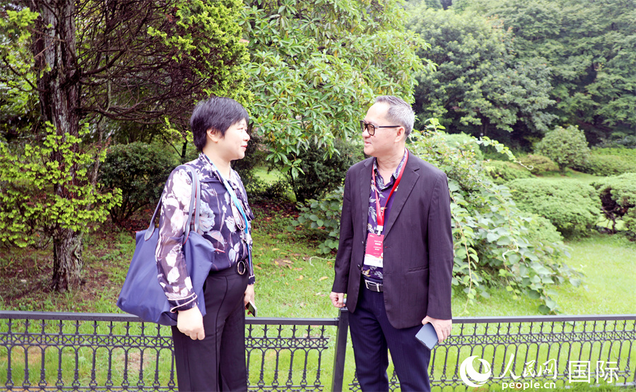 柬埔寨記者俱樂部主席布伊格（右）同復(fù)旦大學(xué)自貿(mào)區(qū)綜合研究院院長(zhǎng)助理盧華（左）在廬山植物園內(nèi)交流。人民網(wǎng)記者 趙益普攝