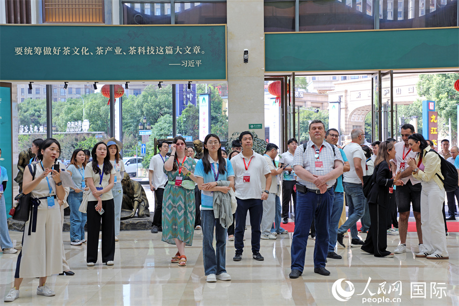 外媒記者在九江茶市展廳內(nèi)聽(tīng)取講解。人民網(wǎng)記者 趙益普攝