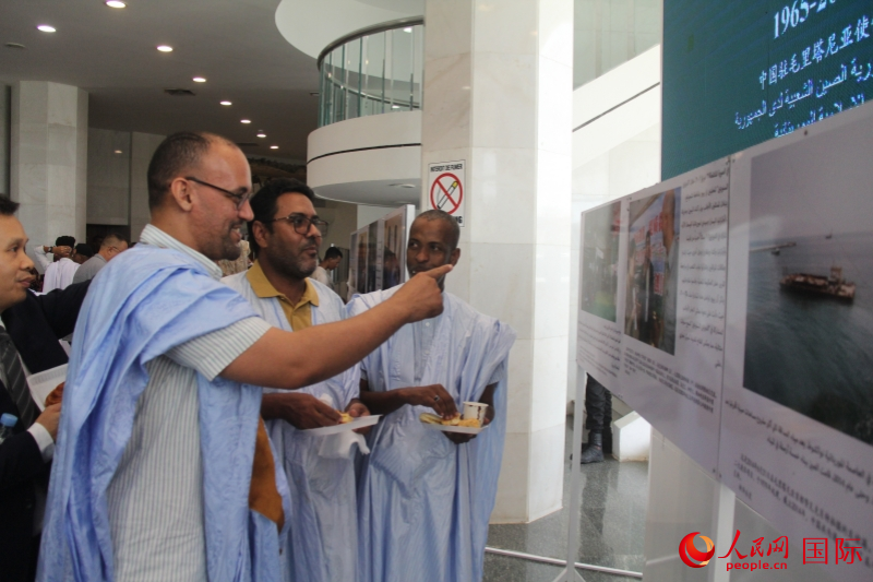 與會(huì)嘉賓對(duì)圖片展興趣濃厚。人民網(wǎng)記者 鄒松攝