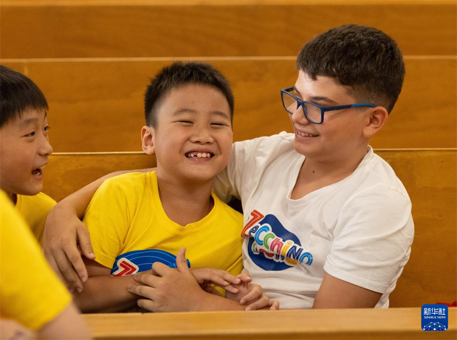 7月18日，在意大利博洛尼亞，繡球花小合唱團團員陸宸（中）與安東尼亞諾小合唱團團員埃利亞·魯比尼在一起玩耍。新華社記者 李京 攝