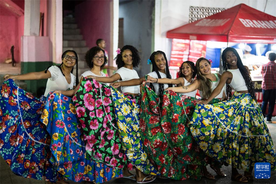 7月19日，在巴西里約熱內(nèi)盧的曼吉尼奧斯社區(qū)，身著傳統(tǒng)服飾的女子在“豐收節(jié)”活動上合影。新華社記者 王天聰 攝