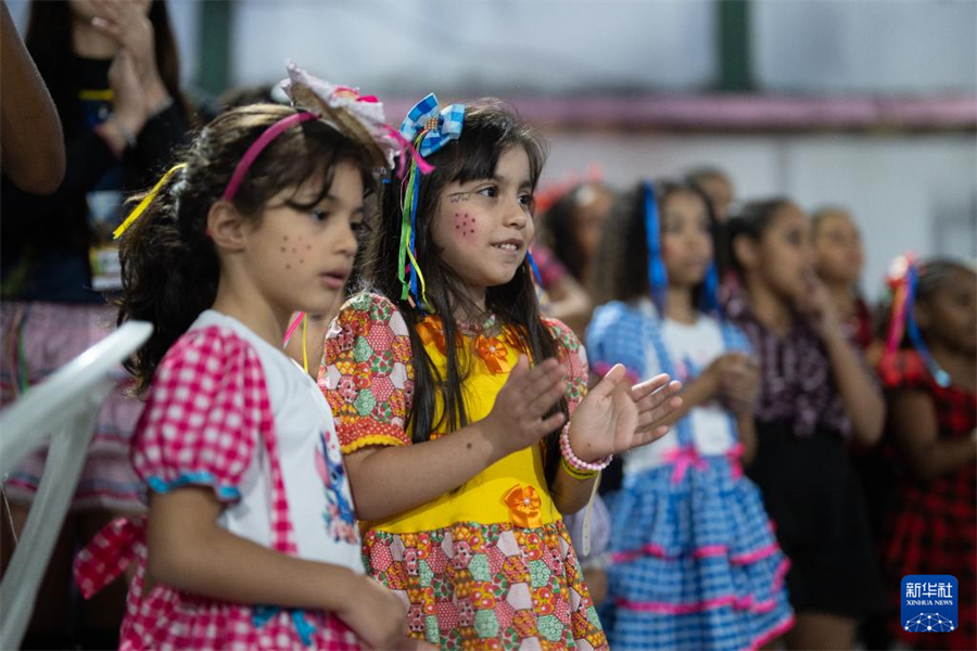 7月19日，在巴西里約熱內(nèi)盧的曼吉尼奧斯社區(qū)，孩子們觀看“豐收節(jié)”活動上的演出。新華社記者 王天聰 攝