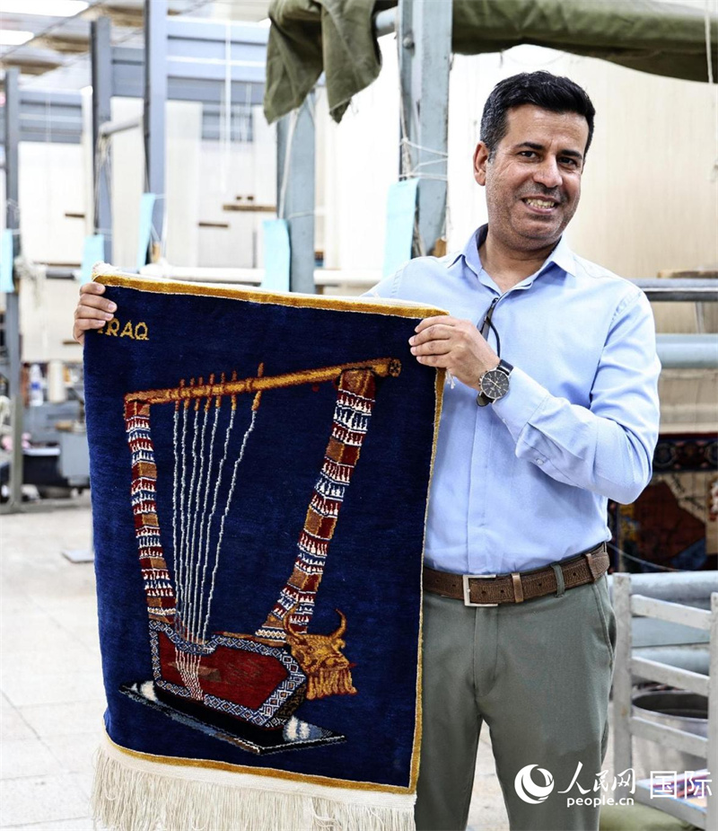 工廠負(fù)責(zé)人在展示一幅掛毯。人民網(wǎng) 伊納斯·易卜拉欣攝