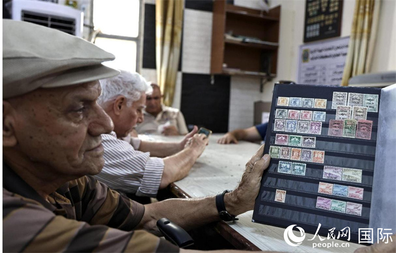 阿卜杜拉展示自己的珍藏郵票。人民網(wǎng)伊納斯·易卜拉欣攝