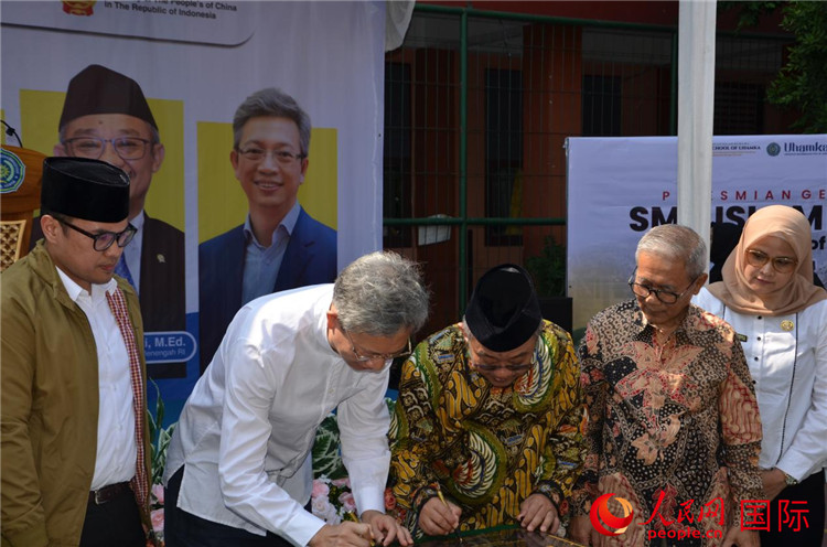 中國駐印度尼西亞大使王魯彤和印尼基礎與中等教育部長穆蒂在簽名板上簽字。人民網(wǎng)記者 李培松攝