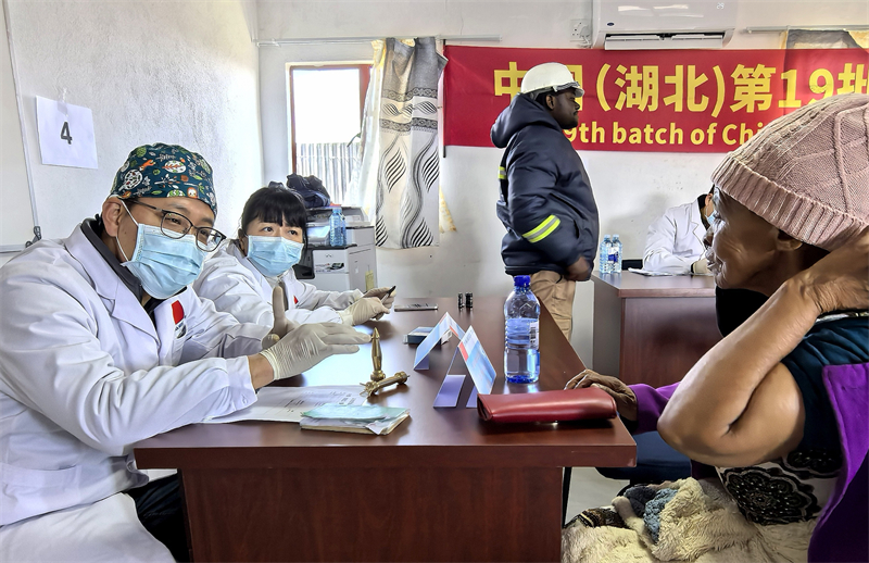 王曉乾（左一）醫(yī)生進行針灸治療。中國援萊醫(yī)療隊 供圖