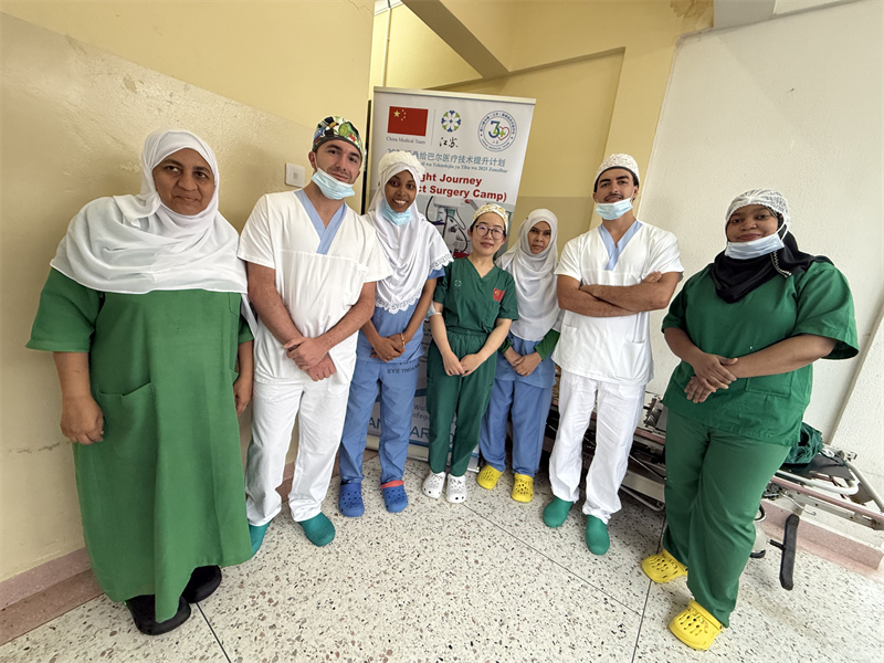 周石醫(yī)生（中）與當?shù)厥中g(shù)團隊合影。中國援桑醫(yī)療隊供圖