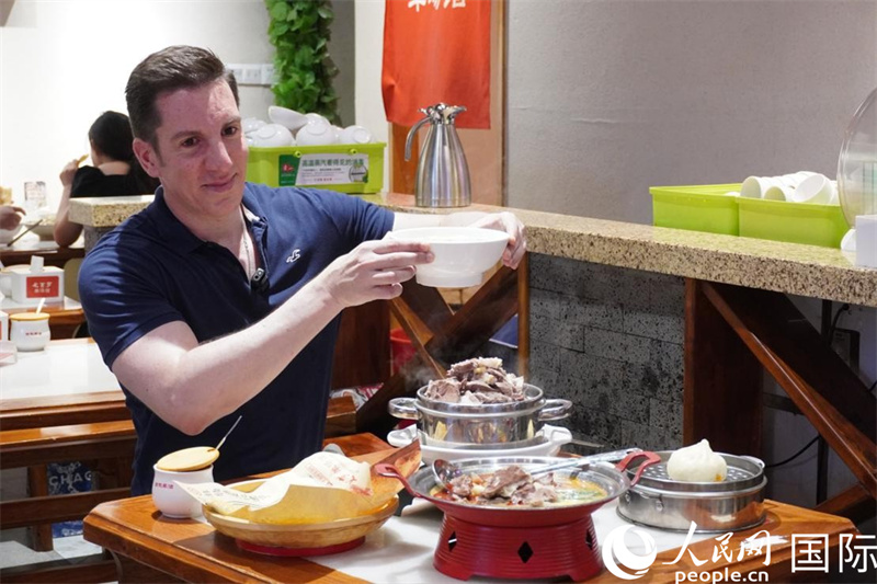 人民網(wǎng)外籍專家湖長(zhǎng)明品嘗伏羊特色美食。 人民網(wǎng) 喻亮攝