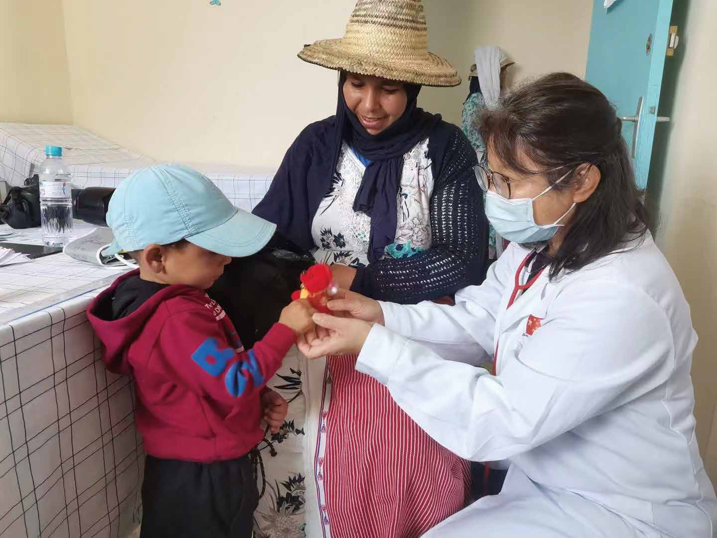 援摩中國醫(yī)療隊員與當(dāng)?shù)孛癖娊涣?。上海市衛(wèi)健委供圖