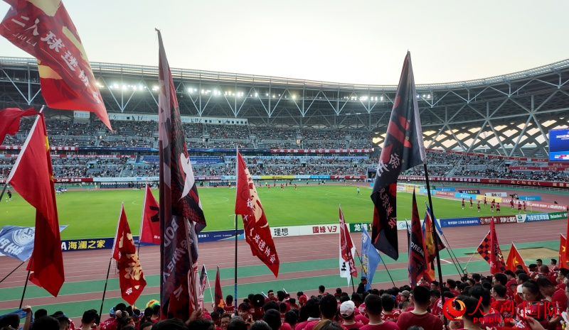 球迷賽前為球隊搖旗加油。人民網(wǎng) 周錦佳攝