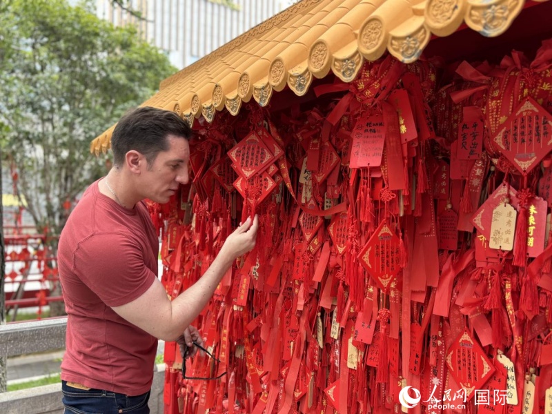 湖長(zhǎng)明在文廟里觀賞許愿牌。人民網(wǎng) 周錦佳攝