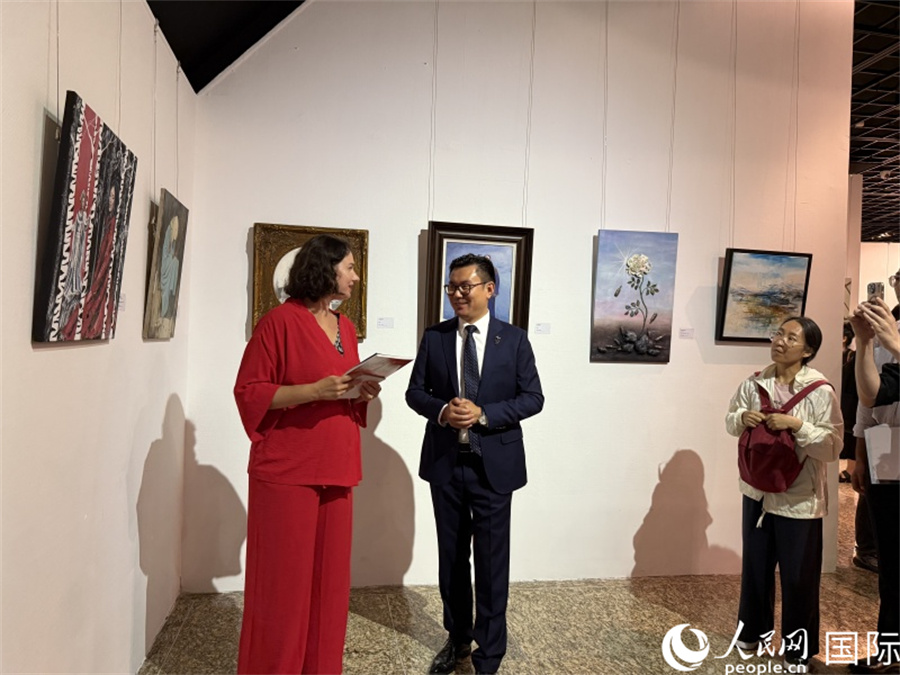 俄羅斯藝術(shù)家伊麗莎白·多羅菲耶娃向現(xiàn)場嘉賓介紹自己的作品。人民網(wǎng)記者 楊倩攝