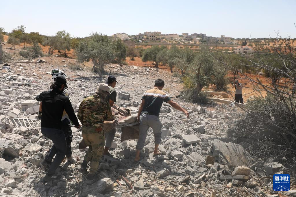 8月14日，在敘利亞伊德利卜，救援人員和居民在爆炸后的廢墟中搜救幸存者。新華社發(fā)