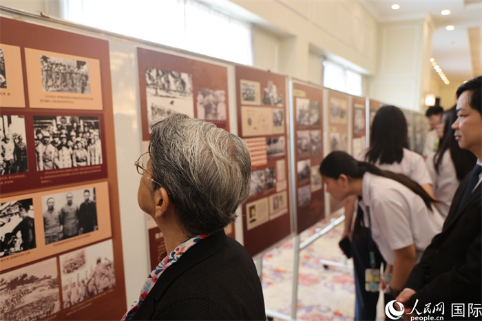 與會代表認真觀看座談會現(xiàn)場舉辦的主題圖片展。人民網(wǎng)記者 樊帆攝