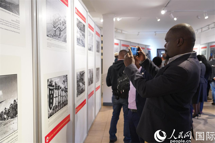 嘉賓在參觀圖片展并拍照記錄。人民網(wǎng)記者 黃煒鑫攝