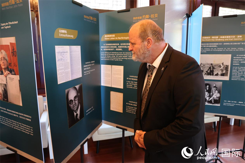 圖為賴因哈特在仔細(xì)觀看介紹拉貝生平的展板。人民網(wǎng)記者 劉仲華攝。