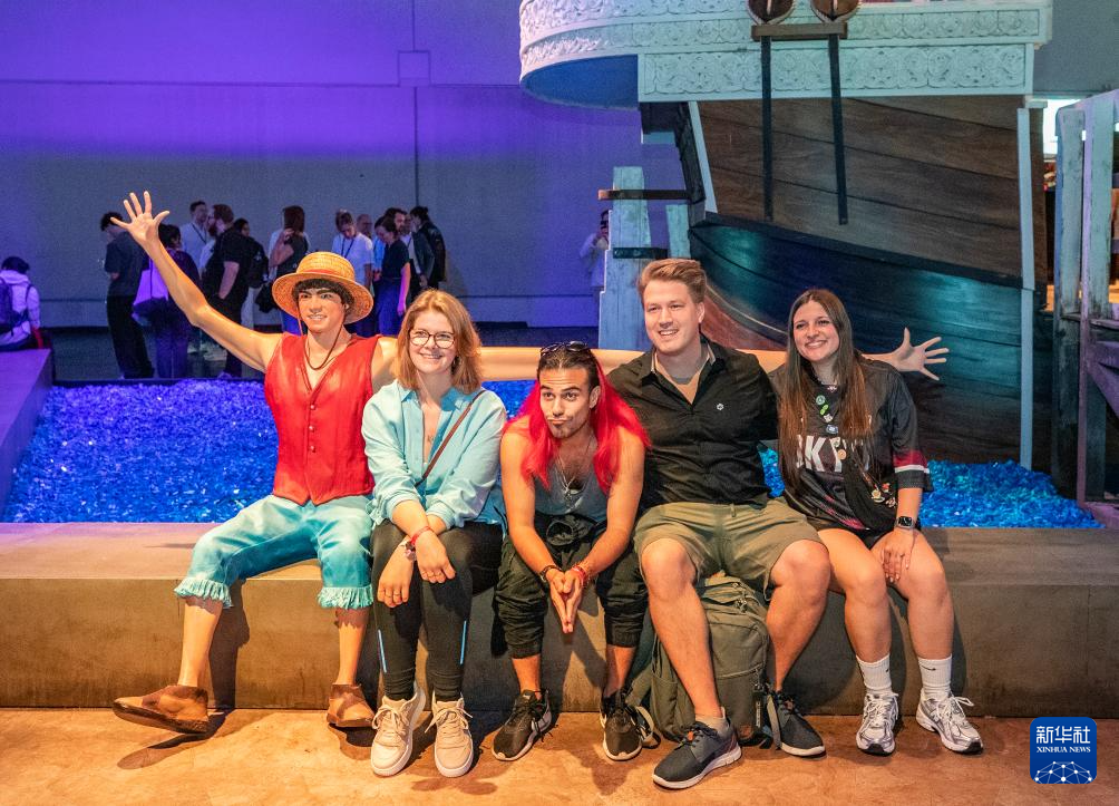 8月20日，在德國(guó)科隆，人們?cè)?025年科隆國(guó)際游戲展上與模型合影。新華社記者 張帆 攝