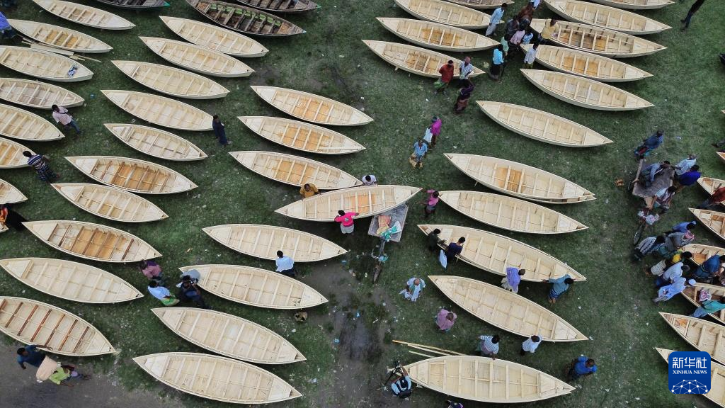 8月20日，人們?cè)诿霞永瓏?guó)馬尼格甘杰的傳統(tǒng)手工木船市場(chǎng)選購(gòu)木船（無(wú)人機(jī)照片）。新華社發(fā)（哈比卜·拉赫曼攝）