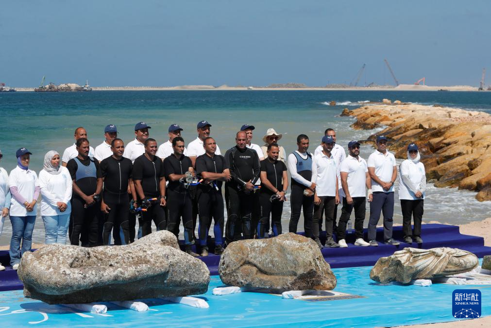 8月21日，在埃及亞歷山大附近的海濱，文物工作者和打撈隊(duì)員與打撈出水的石刻雕像合影。新華社發(fā)（艾哈邁德·戈馬攝）