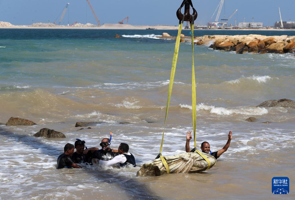 8月21日，在埃及亞歷山大附近的海濱，打撈隊(duì)員慶祝石刻雕像被打撈出水。新華社記者 隋先凱 攝