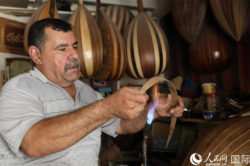 阿里·阿勒阿卜達(dá)迪在烘烤烏德琴琴身木板。人民網(wǎng)伊納斯·易卜拉欣攝