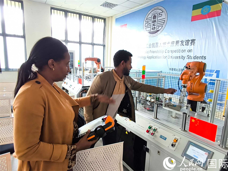 馬哈萊特老師正在教學(xué)生如何操作機(jī)器人。人民網(wǎng)記者 黃培昭攝