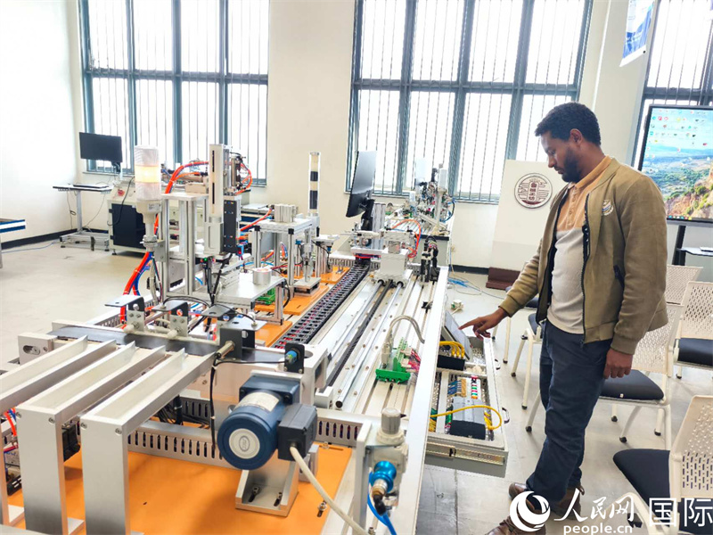 魯班坊Yihun老師正在檢測模擬工業(yè)自動化平臺設(shè)備。人民網(wǎng)記者 黃培昭攝