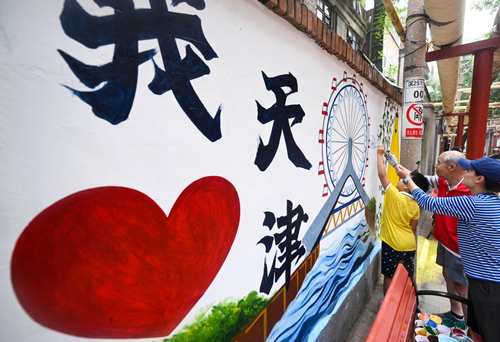 8月15日，在天津市和平區(qū)勸業(yè)場(chǎng)街道兆豐路社區(qū)，志愿者和社區(qū)居民對(duì)一處胡同的老舊墻體進(jìn)行彩繪美化。新華社記者 趙子碩 攝