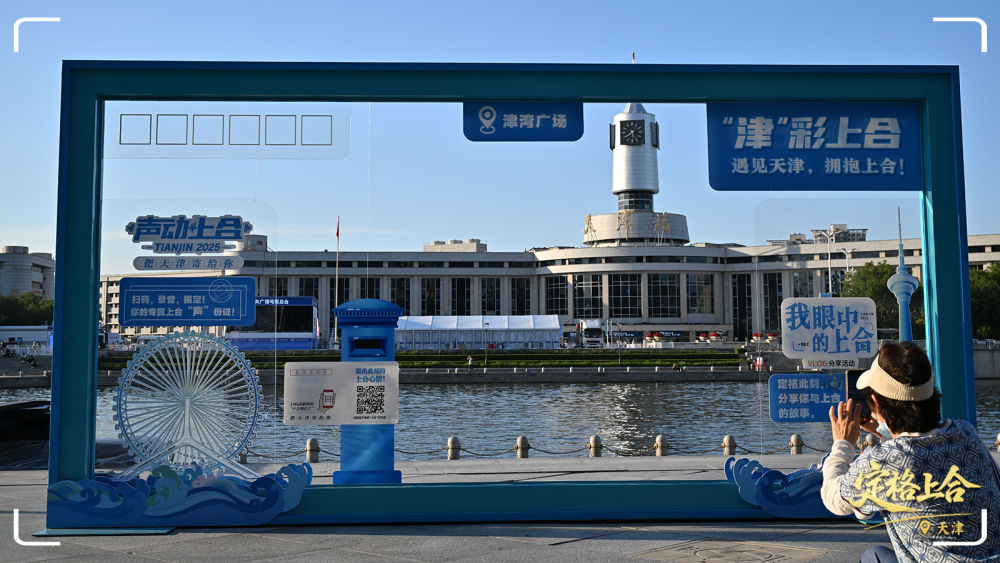 天津津?yàn)硰V場，游客在一處“2025年上海合作組織峰會”主題裝飾物打卡。