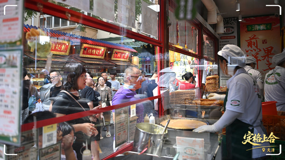市民游客在天津市紅橋區(qū)西北角特色街區(qū)購買煎餅果子。