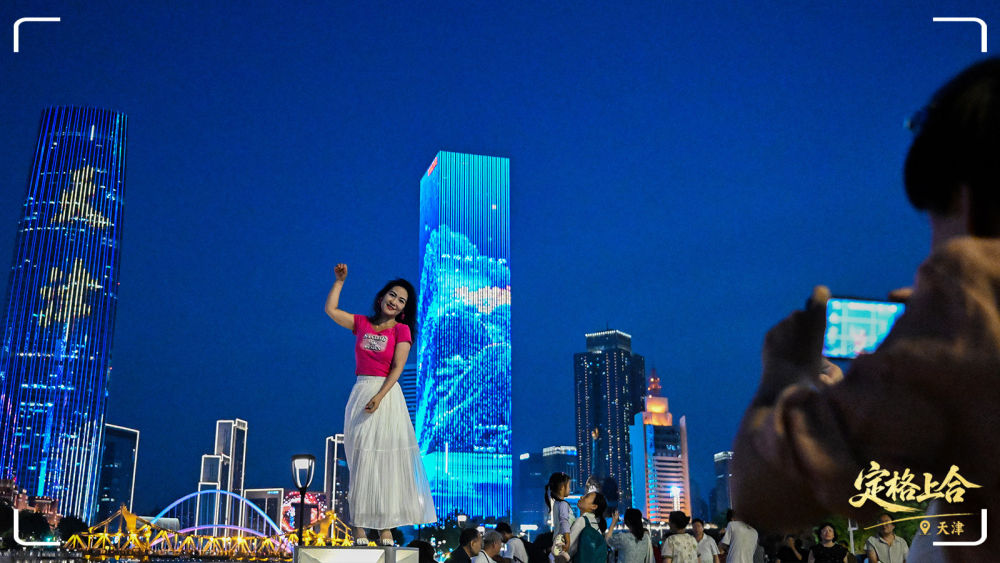 游客在天津市的海河岸邊拍照打卡。