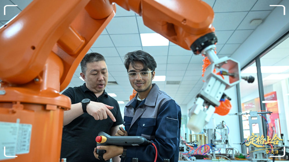 在天津現(xiàn)代職業(yè)技術(shù)學(xué)院魯班工坊實(shí)訓(xùn)教室，教師指導(dǎo)來自巴基斯坦的學(xué)生操作設(shè)備。