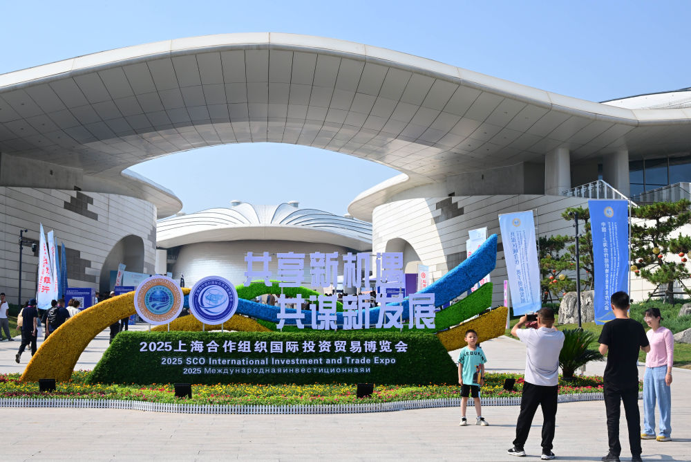 2025年7月18日，人們在青島·上合之珠國際博覽中心外拍照留念。新華社記者 李紫恒 攝